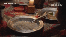 a person sitting at a table with plates of food and a globeplay logo