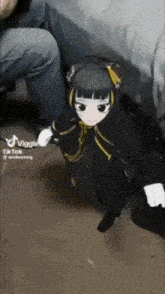 a doll is sitting on the floor next to a person 's knee .