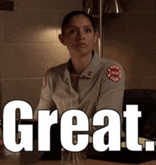 a woman in a chicago fire department uniform is sitting at a desk and says great