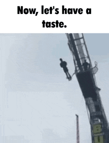 a man is jumping off a crane with a bungee cord attached to him .