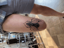 a person has a tattoo of a bee on their thigh