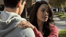 a man and a woman are hugging and looking at each other .