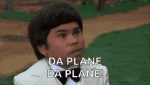 a young man in a tuxedo and bow tie is saying da plane da plane !