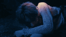 a man in a white sweater is laying on the floor