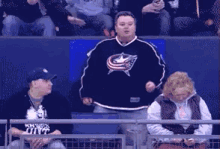 a man in a patriots jersey is dancing in a crowd