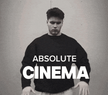a man is wearing a black sweater that says absolute cinema on it