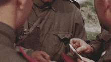 a man in a military uniform holds a piece of paper in his hand