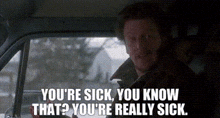 a man is sitting in the back seat of a car and talking to someone .