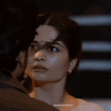 a woman is covering a man 's mouth with her hands .