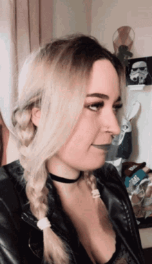 a woman in a braided ponytail wearing a choker and a black jacket