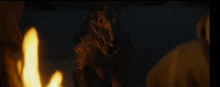 a statue of a dinosaur is standing in front of a fire