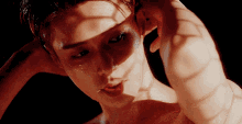 a close up of a shirtless man 's face with a shadow on his face
