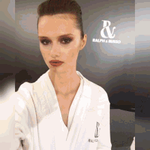 a woman wearing a white robe with ralph & russo written on it