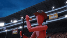 a red mannequin in a cowboy hat is singing into a microphone