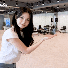 a woman in a white shirt is standing in a room with a sign that says signal on it