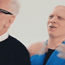 a man in a blue jacket is talking to another man