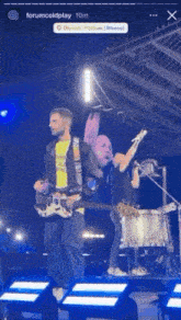 a man is playing a guitar and a woman is singing into a microphone on a stage .
