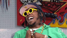 a man wearing sunglasses and a hat laughs