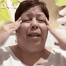 a woman is covering her ears with her hands and smiling .