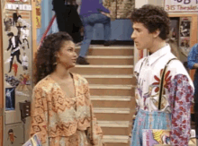 a man and a woman standing next to each other in front of stairs