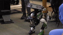 a robot is being tested by a woman wearing blue scrubs