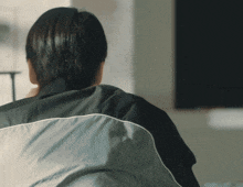 a woman in a black shirt is sitting in front of a blackboard