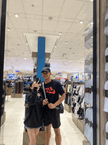 a man in a nike shirt stands next to a woman in a store