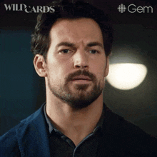 a close up of a man 's face with a wildcards logo in the corner
