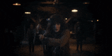 a woman in a brown coat is holding a knife