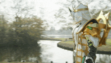 a person in a white and gold costume stands next to a body of water