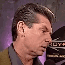 a close up of a man speaking into a microphone with the word royf on it