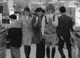 a black and white photo of people walking in a store with a sign that says ' a ' on it
