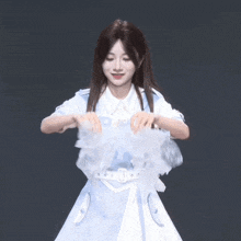 a girl in a white and blue dress is holding a piece of cloth in her hands