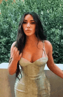 a woman in a snakeskin dress is standing in front of a bush .