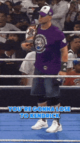 a man in a purple shirt that says last time i saw you 're gonna lose to kendrick is in a ring