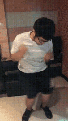 a man wearing glasses and a white shirt is dancing in a room