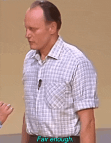 a man wearing a plaid shirt says fair enough