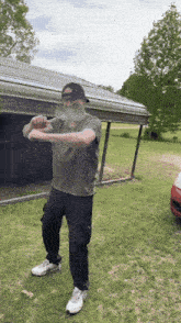 a man with a beard is standing in front of a garage