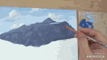 a person is painting a mountain with a brush and the words made in animotica are on the bottom