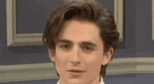 a close up of a young man 's face with a slight smile on his face .