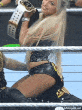 a woman in a wrestling ring is wearing a belt that says ' ivfmorganlust ' on it