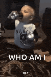 a baby is drinking from a cup with the words who am i on the bottom .