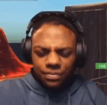 a man wearing headphones and a hoodie is looking at the camera .