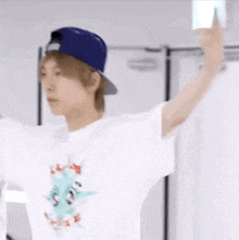 a young man wearing a baseball cap and a white t-shirt is standing in a locker room .