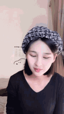 a woman wearing a black sweater and a black hat