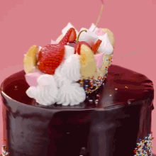 a chocolate cake with strawberries whipped cream and sprinkles