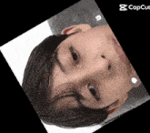 a close up of a person 's face with a capcut icon in the corner
