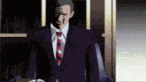 a man in a suit and tie is standing in a dark room
