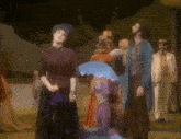 a woman holding an umbrella stands next to a man