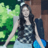 a woman wearing glasses and a plaid top is dancing